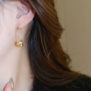 Détail de la boucle d'oreille éléphant en or poli avec un design animal minimaliste