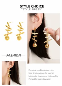 Détail de boucles d'oreilles pendantes dorées à pampilles et perles rondes en métal