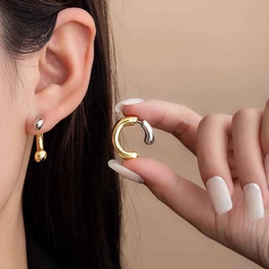 Modern two-tone gold and silver C-shaped fluid earrings with a polished metal finish
