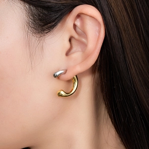 Minimalist silver and gold C-shaped earrings with a sleek two-tone metallic design