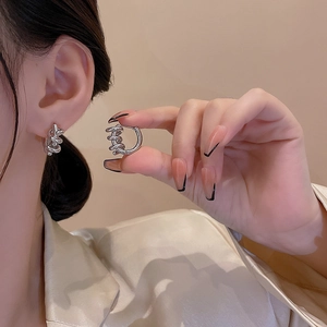 Elegant silver twisted spiral hoop earrings with minimalist French style on model