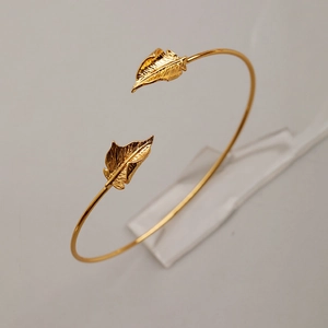 Close-up of golden leaf open bracelet showing intricate vein details and metallic luster