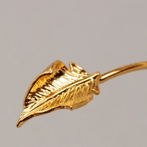 Macro shot of detailed leaf texture and golden veins on an elegant wave bangle