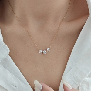 Elegant gold choker necklace with three minimalist micro-set diamonds on a female model