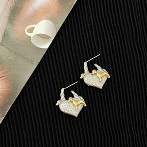 Two-tone heart puppy earrings with silver textured surface and golden dog charm