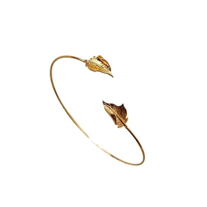 Elegant gold ginkgo leaf open bangle with detailed leaf veins on a minimalist white background