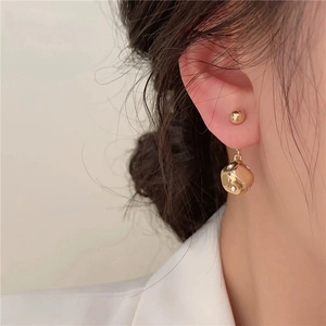 Chic gold spherical stud earrings with geometric rhinestone pendant on female model