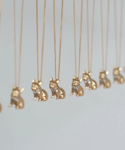 Gros plan de pendentifs bouledogue français dorés avec colliers sertis de strass brillants