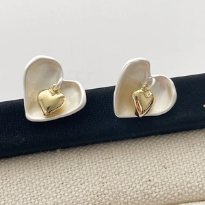 Boucles d'oreilles cœur bicolores avec design emboîté blanc mat et or poli