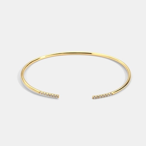 Elegant gold open cuff bangle featuring minimalist zircon bars on a clean gray background