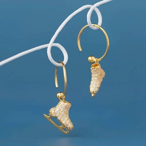 Elegant gold ice skate hoop earrings with sparkling zircon crystals in a side view