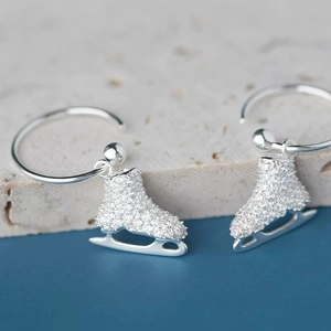 Elegant silver ice skate drop earrings featuring shimmering zircon pave and polished blades