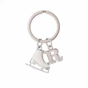 Detail of silver keyring featuring a white ice skate charm with rhinestones and letter R