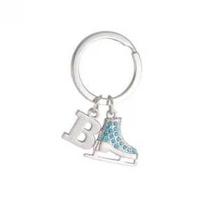 Detail view of silver skate charm with blue rhinestones and polished metal letter B