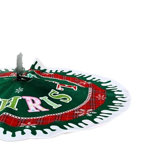 Christmas tree skirt with red and green plaid patterns and white snowflake prints