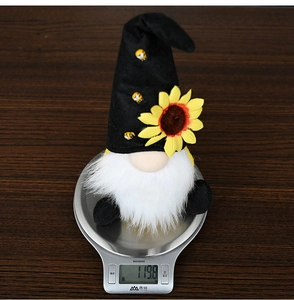 Detail shot of a sunflower gnome plush weighing 119.8g on a scale for fall decoration