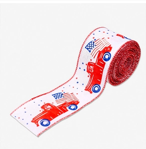 Close-up of patriotic ribbon roll with vintage red truck and US flag for Independence Day
