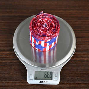 Close-up showing the precise 66.9g weight of the patriotic star and stripe pattern ribbon