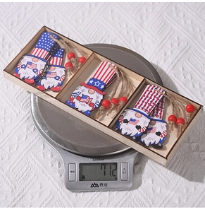 Detailed view of patriotic gnome wood ornaments in a wooden box weighing 71.2g on a scale