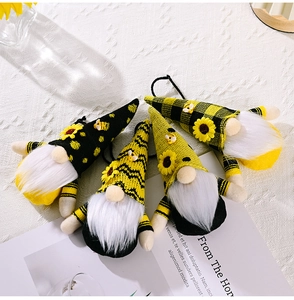 Détail de quatre poupées gnomes de tournesol avec tricot jaune et noir sur tissu