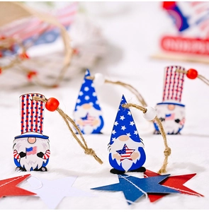 Close-up of wooden Independence Day gnome ornaments with red and white beads and jute twine