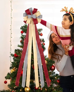 Family placing a large 30-inch plaid multi-layered Christmas tree topper bow with long streamers