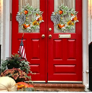 Detailed autumn wreaths with pumpkins, berries, and bows on red doors for Thanksgiving decor