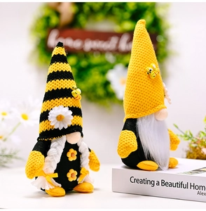 Macro detail of bee-themed gnome plush toys with yellow stripes and daisy accents