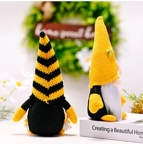 Detail of bee themed gnomes plush set with striped knit hats and daisy floral decor