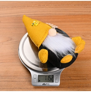 Bee gnome plush on electronic scale showing product weight of 115.2g for home decor