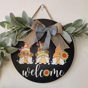 Detail of sunflower gnome welcome door sign with burlap bows and artificial leaves