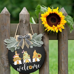 Farmhouse sunflower welcome wreath with gnome prints and black-white plaid bow on wooden fence