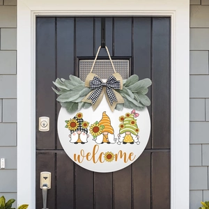 Close-up of wooden welcome gnome sign with sunflower decor and burlap bows on front door