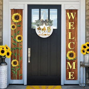 Detail of farmhouse sunflower welcome banners and gnome door sign on a black front door