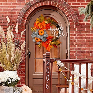 Autumn wreath with hello Fall sign, pumpkin, berries and black white striped bow on door