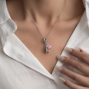 Détail du collier en acier titane avec pendentifs tour Eiffel, appareil photo et cœur