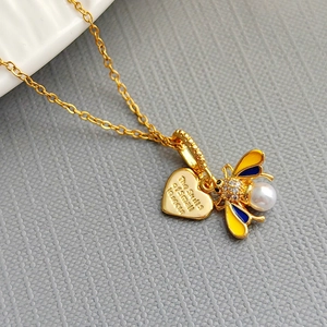 Collana con ciondolo a cuore dorato e ape smaltata con perla su espositore testurizzato