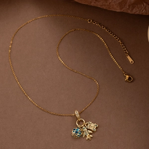Collier avion doré avec globe en émail bleu et charmes de voyage sur fond marron élégant