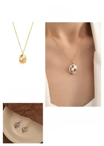 Detail of vintage oval pendant with pink zircon flower and faux pearls in gold titanium