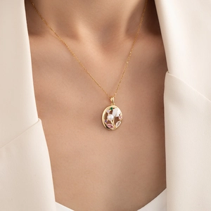 Elegant gold oval flower pendant necklace with pink zircon and pearl on a model