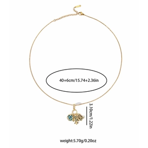 Détails du collier voyage avion avec globe bleu et pendentif éléphant sur chaîne dorée