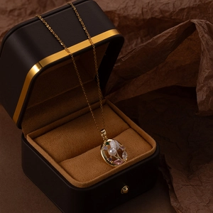 Detailed close-up of a flower zircon pendant in a black gift box on brown crinkle paper