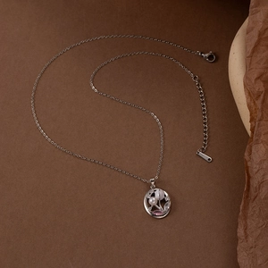 Silver flower necklace with pink zircon and white pearl on vintage brown background