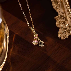 Detailed close-up of a golden badminton racket and shuttlecock pendant on a thin chain