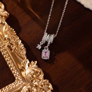 Close-up of silver tassel pendant with pink square zircon and micro-pave crystals