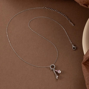 Silver badminton racket necklace with pink enamel shuttlecock on brown vintage paper