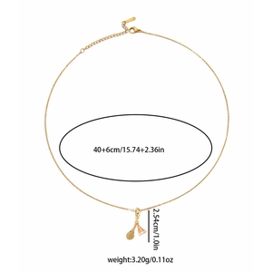Detailed view of gold shuttlecock and racket charms on a dainty titanium necklace