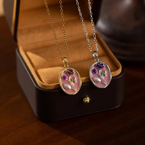 Detail of vintage enamel purple rose pendants with baroque pearls on titanium steel chains