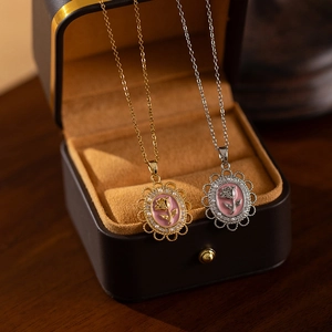 Close-up of vintage rose pendant necklaces in gold and silver finish with pink relief