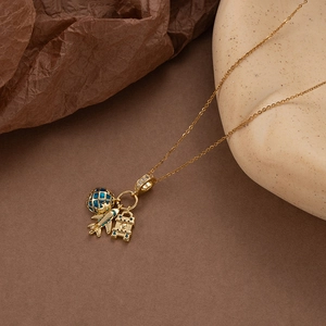 Collier doré sur le thème du voyage avec pendentifs globe avion et valise sertis de zircons